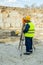 Young surveyor in workwear using geodetic station