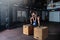 Young sweaty muscular fit girl with big muscles and strong legs doing deep squat and dip on two wooden jump boxes with heavy kettl