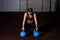 Young sweaty muscular strong fit girl holding big heavy barbell weight plate with her hands and circling around her head as hard