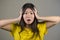 Young sweet and beautiful Asian Korean woman gesturing shocked and surprised as if oh my god what a disaster in astonished face ex