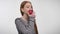 Young sweet ginger girl is biting red apple, enjoying it, white background