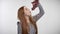 Young sweet ginger girl is eating grape, enjoying it, white background