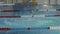 Young swimmer dives in the water of a training pool indoors