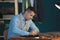 Young tailor marking fabric with chalk in atelier