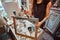 Young talented painter is restourating old frame in her own workshop
