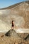 Young tanned male model posing in front of a volcano crater