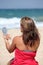 Young tanned woman putting make up on whilst on the beach