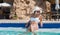 Young tanned woman relaxing in swimming pool spa wearing white h