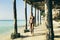 Young tanned woman walks along coastline ocean sunset