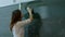 Young teacher erasing chalkboard.