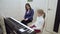 Young teacher with little cute girl playing on the electric piano.