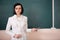 Young teacher woman on green board