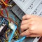 The young technician hold the cord for repairing the computer in his hand. Computer hardware, service, upgrade