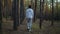 Young teen boy walking in the pine tree forest