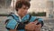 Young teen chatting cellphone outdoors closeup. Curly guy communicating mobile