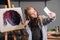 Young teen girl cute posing for a selfie in the workshop. she is happy with her first picture.