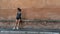 Young teen girl with headband, shorts, tanktop and sneakers sitting on brick bench