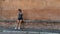 Young teen girl with headband, shorts, tanktop and sneakers sitting on brick bench