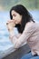 Young teen girl praying quietly on lake pier