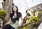 Young teen girl sitting on branches of flowering cherry tree