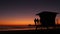 Young teen girls silhouettes, lifeguard watch tower, friends on pacific ocean beach, California USA.