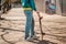 A young teen poses with a skateboard. In the background, an alley. Close up. Concept of sports lifestyle and street culture