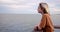 Young teenage boy enjoys summer day at the wooden pier by the ocean