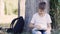 Young teenage boy sitting on the grass and using digital tablet