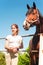 Young teenage girl equestrian standing close to big chestnut horse