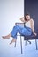 young teenage girl fighting brain cancer sitting on black chair on white background in studio