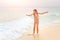 Young teenage girl having fun with waves on beach