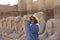 Young teenage girl in karnak Temple with sphinx statues in the background in Luxor in Egypt