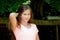 Young teenage girl in the park with smilling facial expression.