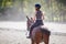 Young teenage girl riding her horse at training