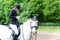 Young teenage girl riding horseback preparing her clothes to com