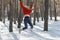 Young teenage girl in snowy forest jumps high. Walk through the winter wood on sunny day