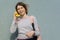 Young teenage girl talking on the phone, holding in hands abstract telephone receiver banana. Copy space, outdoor gray background.