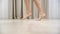 Young teenage girl walking tiptoe barefoot on a warm wooden floor at home