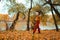 a young teenage girl walks through the autumn forest, walks along the riverbank and enjoys the beautiful nature and bright yellow