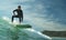 A young teenage male surfer rides a surfboard on a wave at Piha beach, Auckland, New Zealand