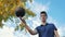 A young teenage man spins the ball on his finger while on the basketball court.