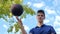 A young teenage man spins the ball on his finger while on the basketball court.