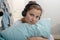 Young teenage sitting on bed in bedroom listen to music with headphones
