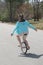 Young Teenage Woman Riding Down A Residential Neighborhood Street Balancing on a Unicycle