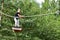 Young teenage woman in a treetop rope park adventure