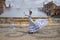 Young teenage woman in white suit with black polka dots, dancing flamenco in front of water fountain and surrounded by soap