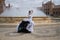 Young teenage woman in white suit with black polka dots, dancing flamenco in front of water fountain and surrounded by soap