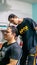 Young teenager applying a hair cream product to straighten the curly hair of his friend