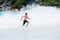 Young teenager boy enjoys summer holiday in sea. The kid runs away from huge wave.