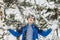 Young teenager boy throw snow up in front of him in the winter forest f